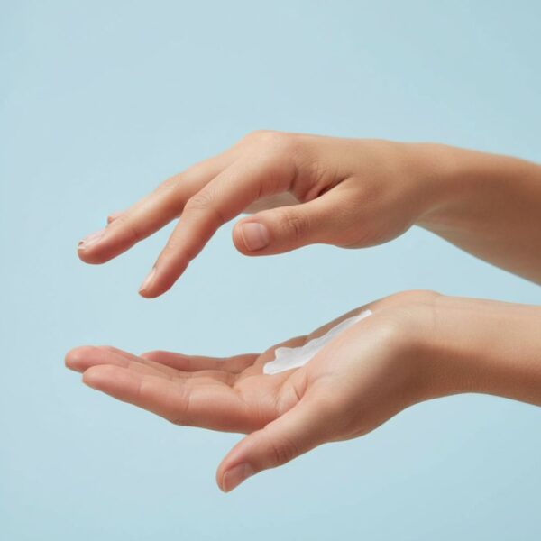 A pair of hands cups sunscreen lotion in one palm, ready to be applied. 