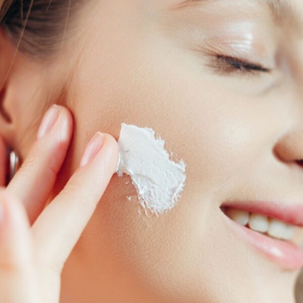 Woman applying SPF to her skin.